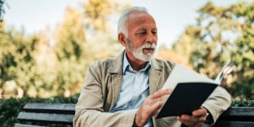 Charming old man reading a book.